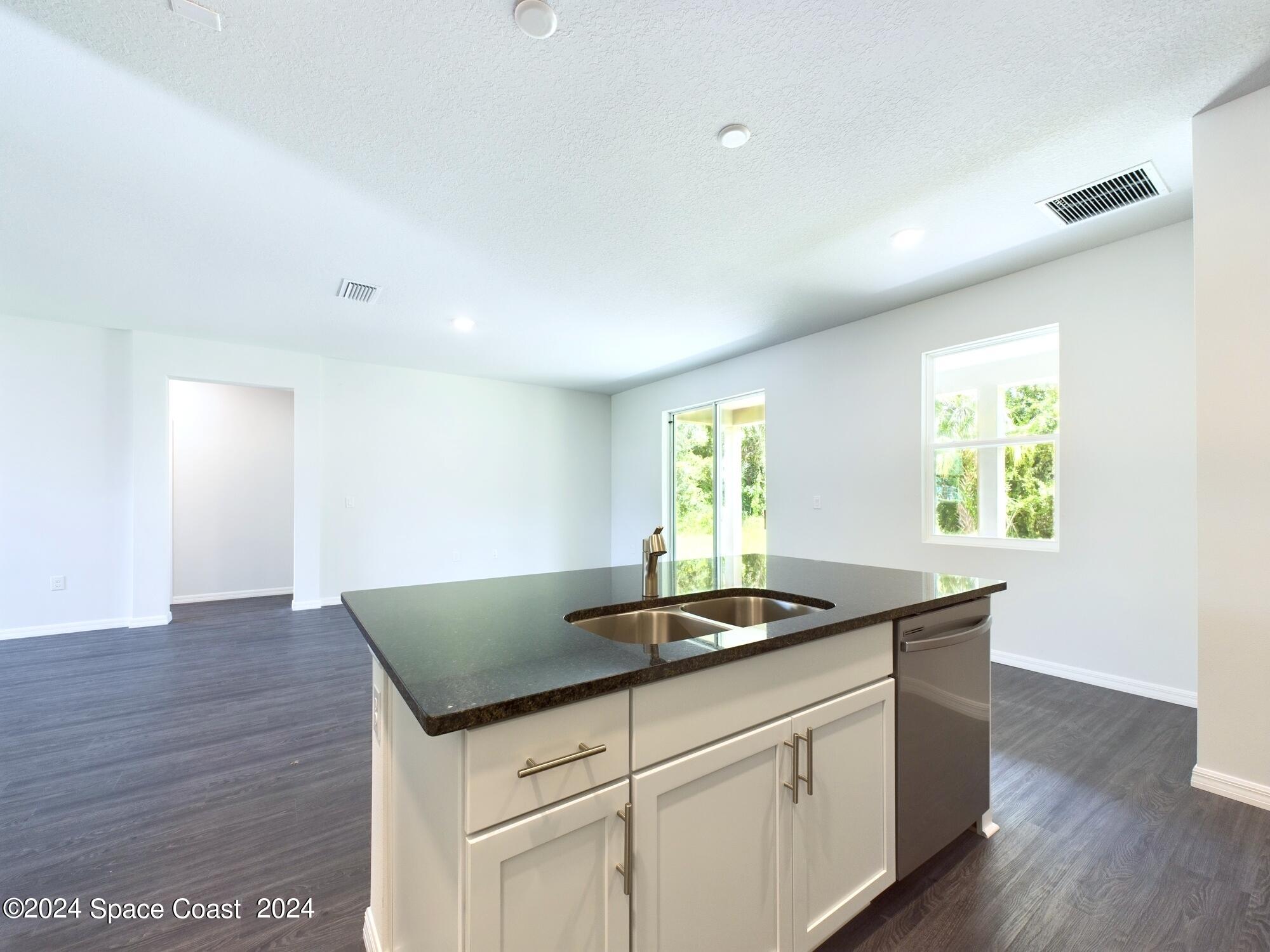 842 Angelico Road Northwest Palm Bay, FL 32907 - Photo 7 of 22 a kitchen with granite countertop a sink and a window