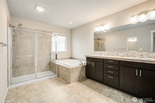 a spacious bathroom with a tub sink shower and mirror