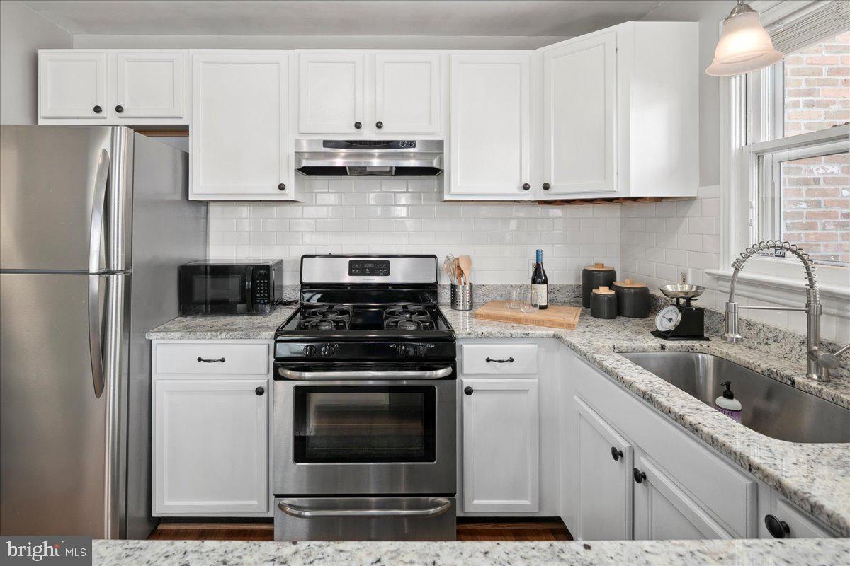 802 Pendleton Street Alexandria, VA 22314 - Photo 16 of 36 a kitchen with stainless steel appliances granite countertop a sink stove and refrigerator