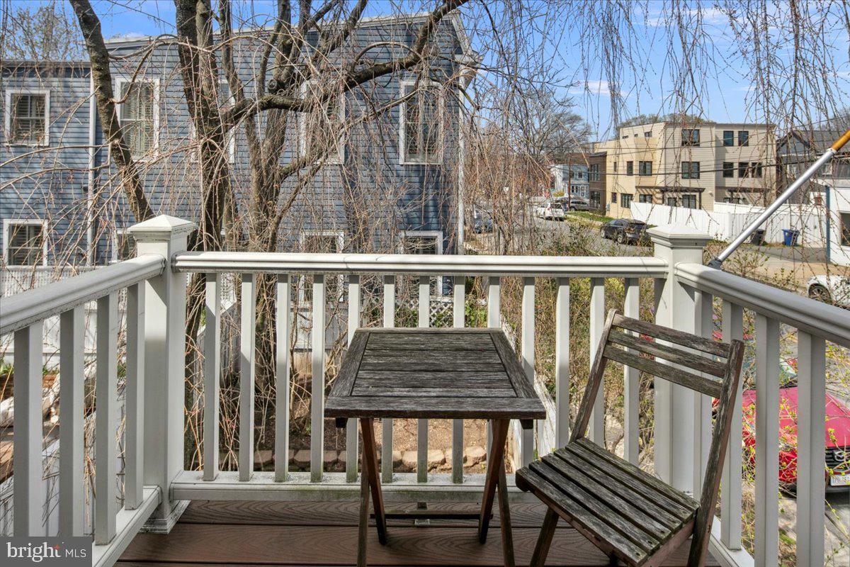 802 Pendleton Street Alexandria, VA 22314 - Photo 30 of 36 a view of a balcony with wooden chairs and wooden fence