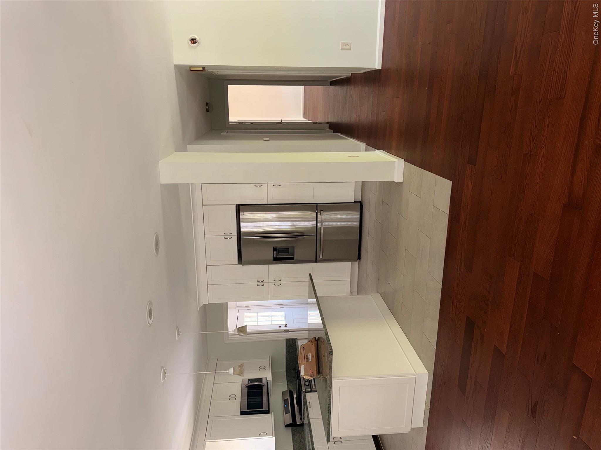 1661 Old Country Road, Unit 516 Riverhead, NY 11901 - Photo 9 of 50 a view of a kitchen cabinets and wooden floor