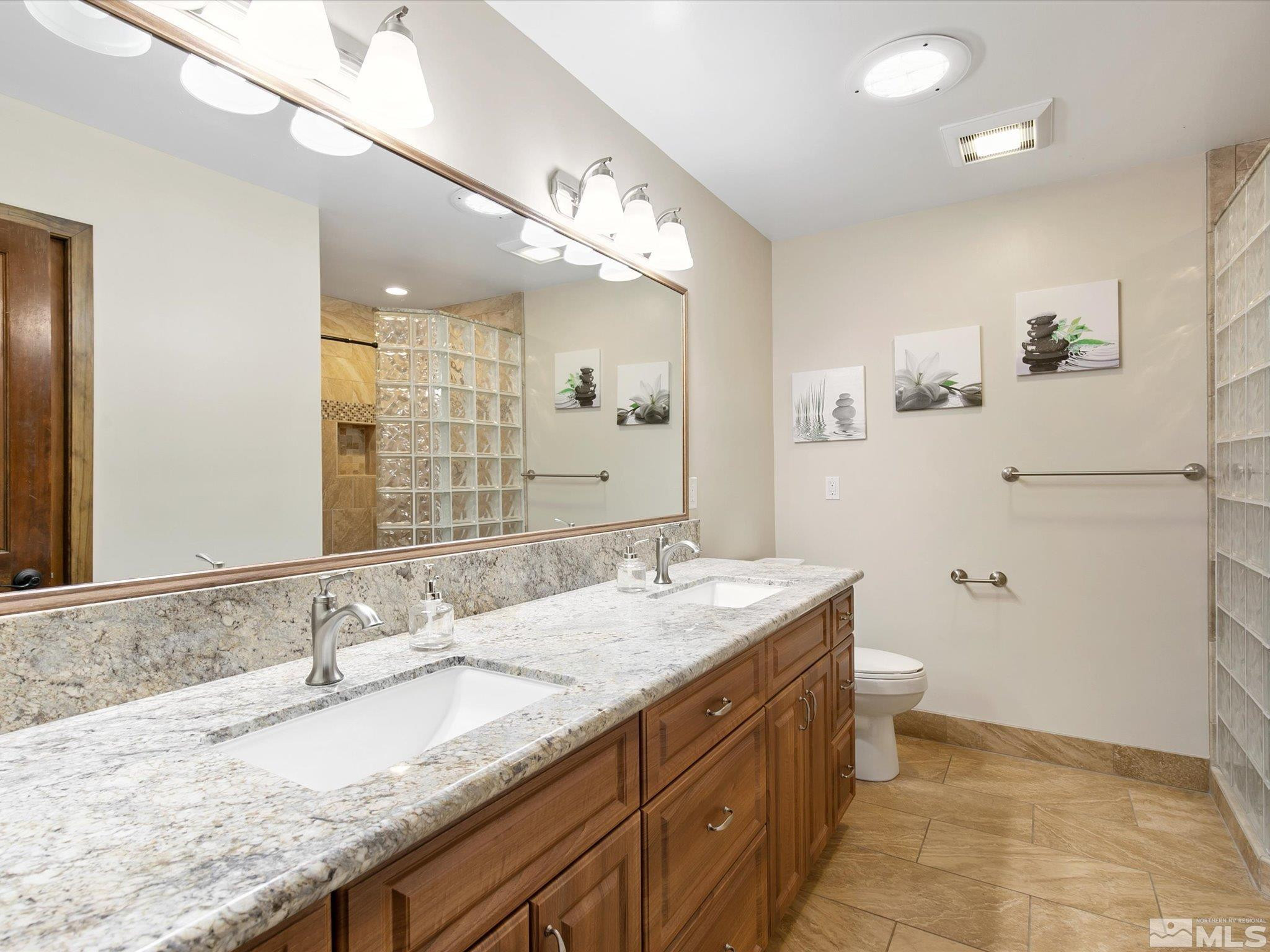 3750 Buckskin Road Carson City, NV 89703 - Photo 15 of 38 a bathroom with a granite countertop sink a mirror and a toilet