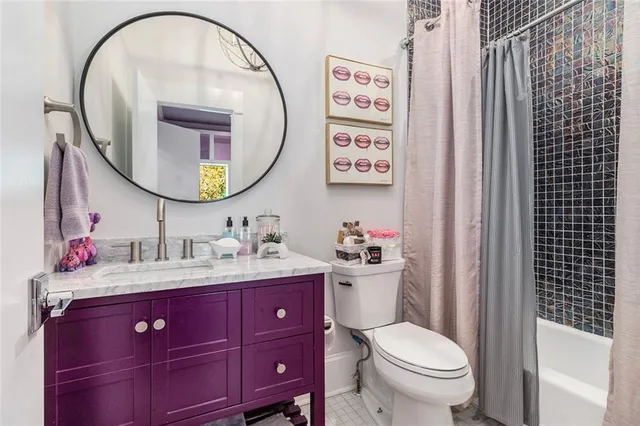 a bathroom with a granite countertop toilet sink and mirror