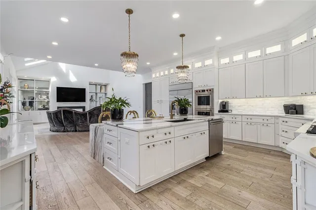 a kitchen with stainless steel appliances a dining table chairs stove and refrigerator