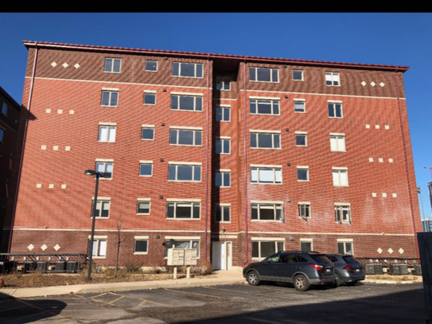 231 West 18th Street, Unit 2A Chicago, IL 60616 - Photo 1 of 9 a front view of a building with lot of cars and trees