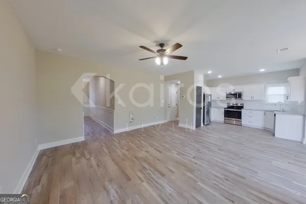 a view of an empty room with a kitchen
