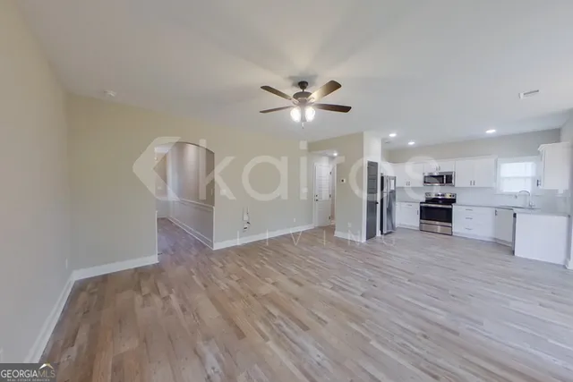 a view of an empty room with a kitchen