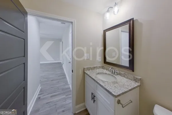 a bathroom with a granite countertop sink a mirror and vanity