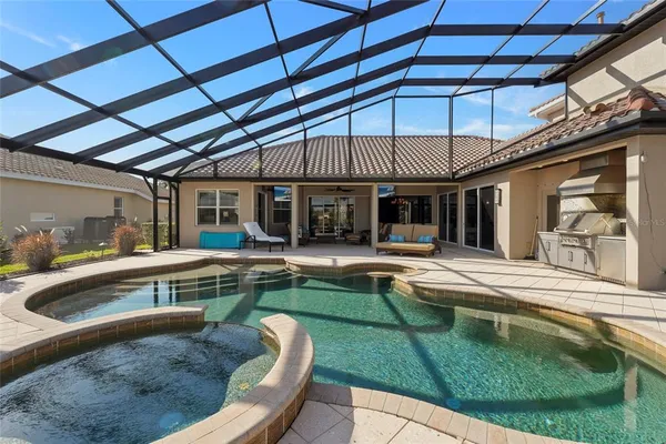 a kitchen with stainless steel appliances kitchen island granite countertop a dining table chairs refrigerator and sink