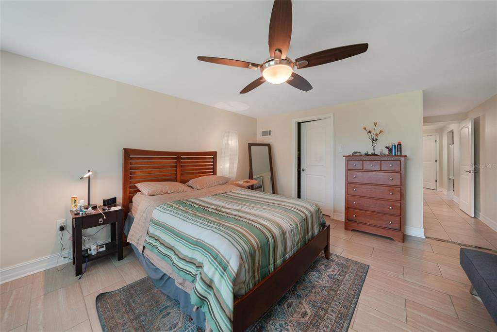 3119 Pinetree Street Port Charlotte, FL 33952 - Photo 13 of 23 a bedroom with a bed a dresser and a chandelier