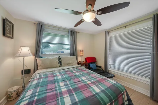 a bedroom with a bed chandelier and a window