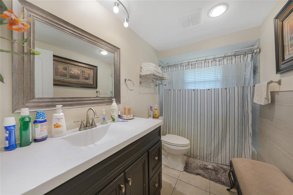 3119 Pinetree Street Port Charlotte, FL 33952 - Photo 19 of 23 a bathroom with a sink a toilet a shower and a mirror