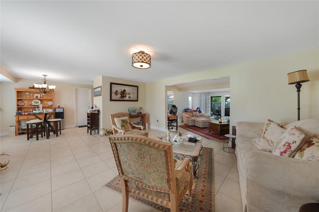 3119 Pinetree Street Port Charlotte, FL 33952 - Photo 4 of 23 a view of a dining room and livingroom with furniture wooden floor a rug a painting and a chandelier