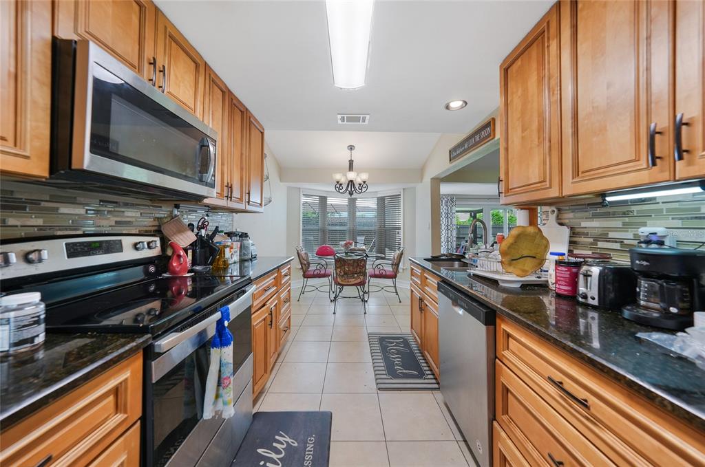 3119 Pinetree Street Port Charlotte, FL 33952 - Photo 6 of 23 a kitchen with stainless steel appliances granite countertop a stove top oven a sink dishwasher and cabinets with wooden floor