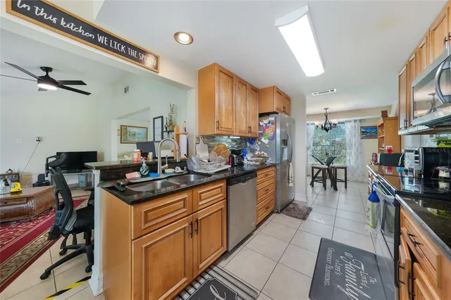 a kitchen with stainless steel appliances sink stove refrigerator and cabinets