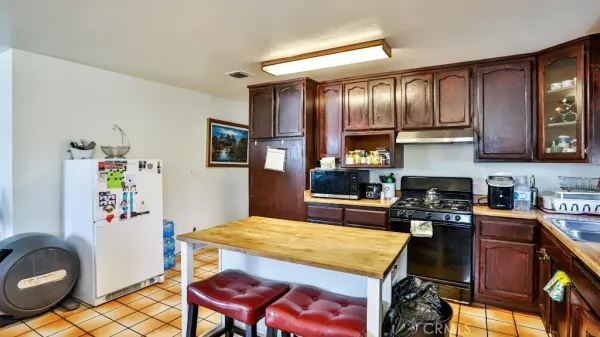 a kitchen with stainless steel appliances granite countertop a stove refrigerator sink and cabinets