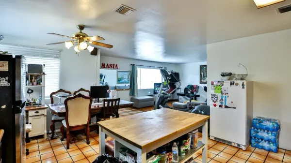 a open kitchen with stainless steel appliances granite countertop a stove top oven a dining table and chairs with wooden floor