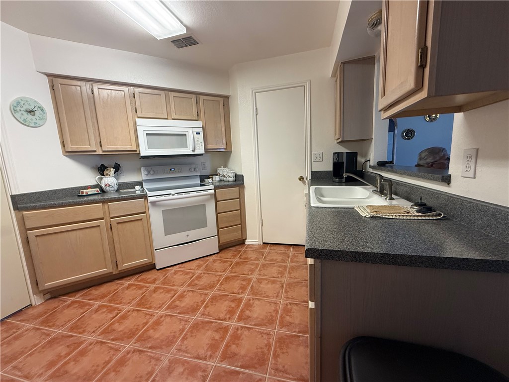 113 Santa Fe Rockport, TX 78382 - Photo 13 of 25 a kitchen with a sink stove and cabinets