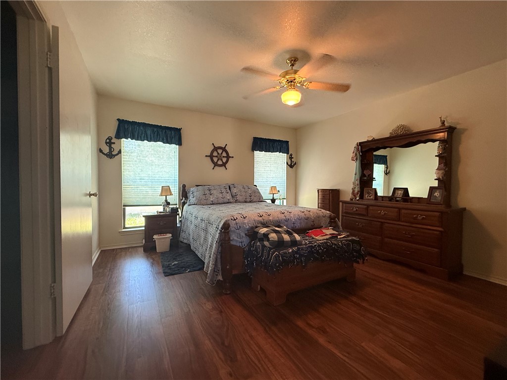 113 Santa Fe Rockport, TX 78382 - Photo 14 of 25 a bedroom with a bed and wooden floor