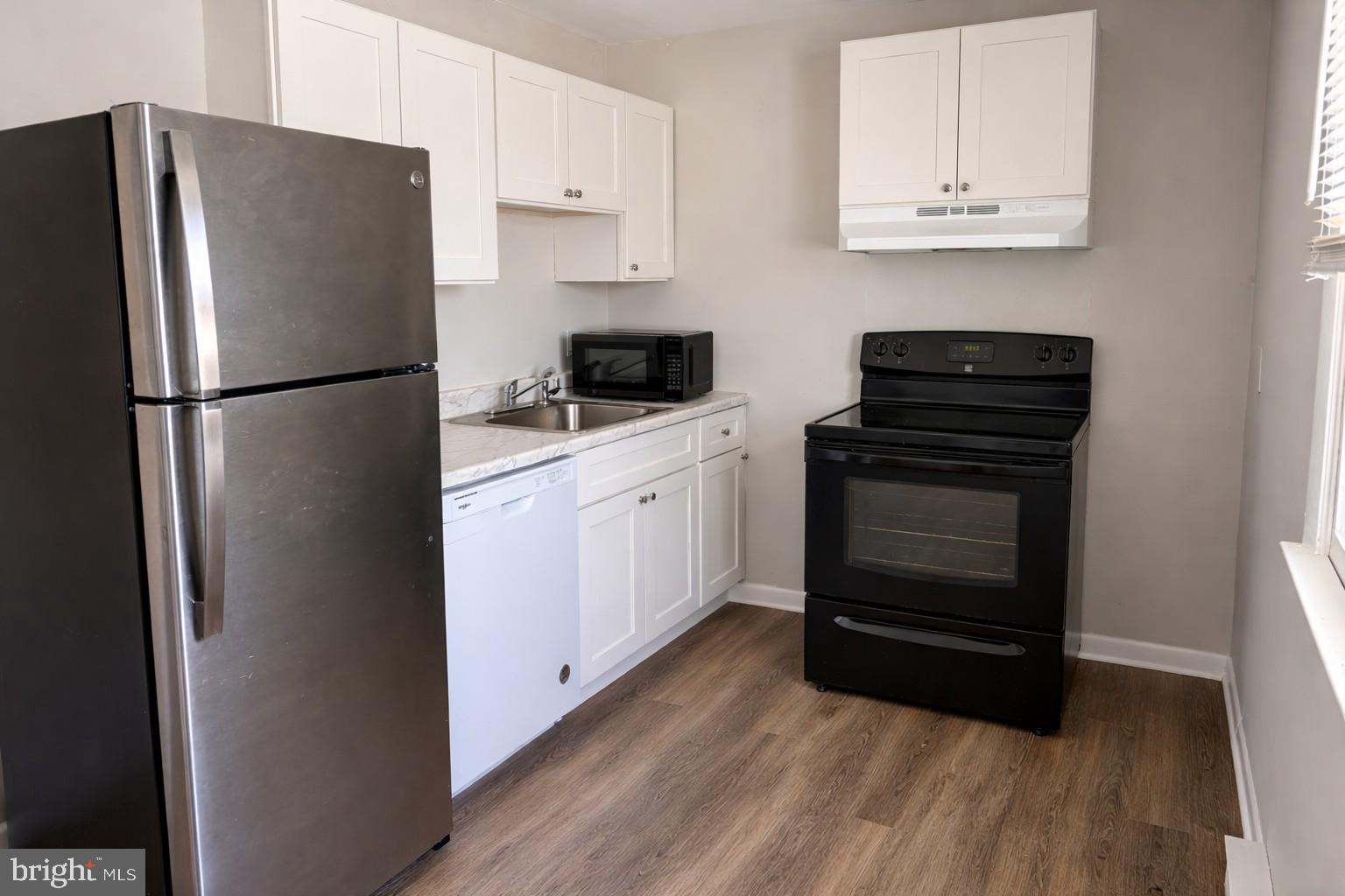 a kitchen with a refrigerator sink and cabinets