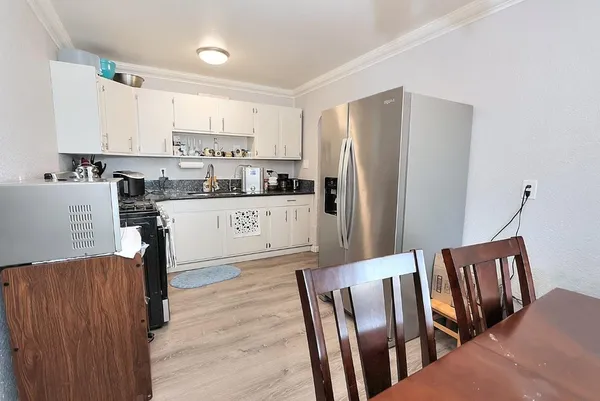 a kitchen with stainless steel appliances wooden floor and wooden cabinets