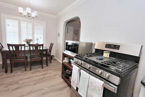 a kitchen with a stove and wooden floor