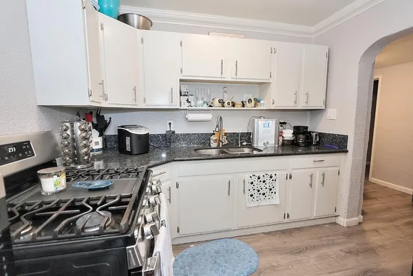 a kitchen with a stove and white cabinets