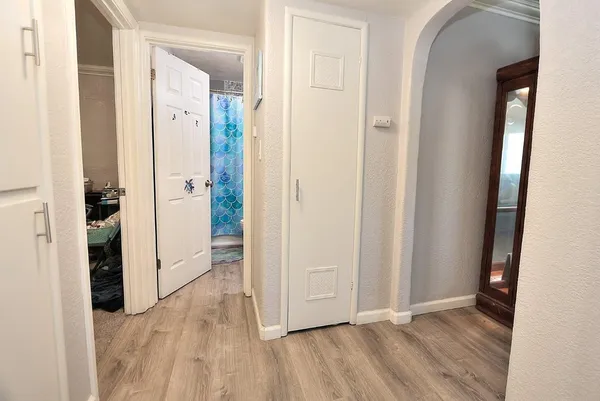 an empty room with wooden floor and a bathroom