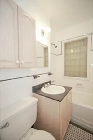 a bathroom with a sink a toilet and shower