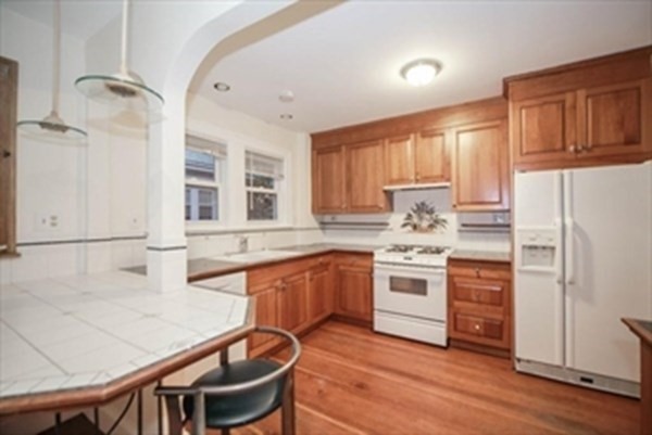 35 Greycliff Road, Unit 2 Boston, MA 02135 - Photo 3 of 26 a kitchen with stainless steel appliances granite countertop a stove a sink dishwasher and a refrigerator with wooden floor