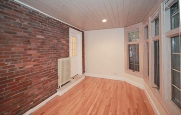35 Greycliff Road, Unit 2 Boston, MA 02135 - Photo 7 of 26 a view of an empty room with wooden floor and a window