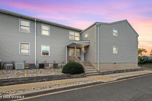 213 Main Street, Unit 4 Keansburg, NJ 07734 - Photo 2 of 11 a front view of a house with white fence and a garage