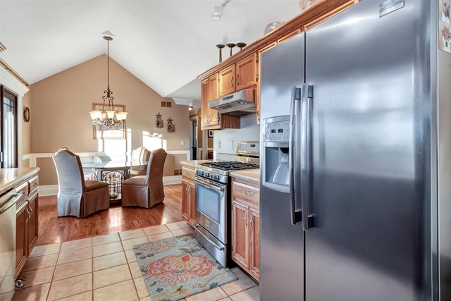 741 Longlane Road New Lenox, IL 60451 - Photo 9 of 28 a kitchen with stainless steel appliances granite countertop a refrigerator a sink dishwasher a dining table and chairs with wooden floor