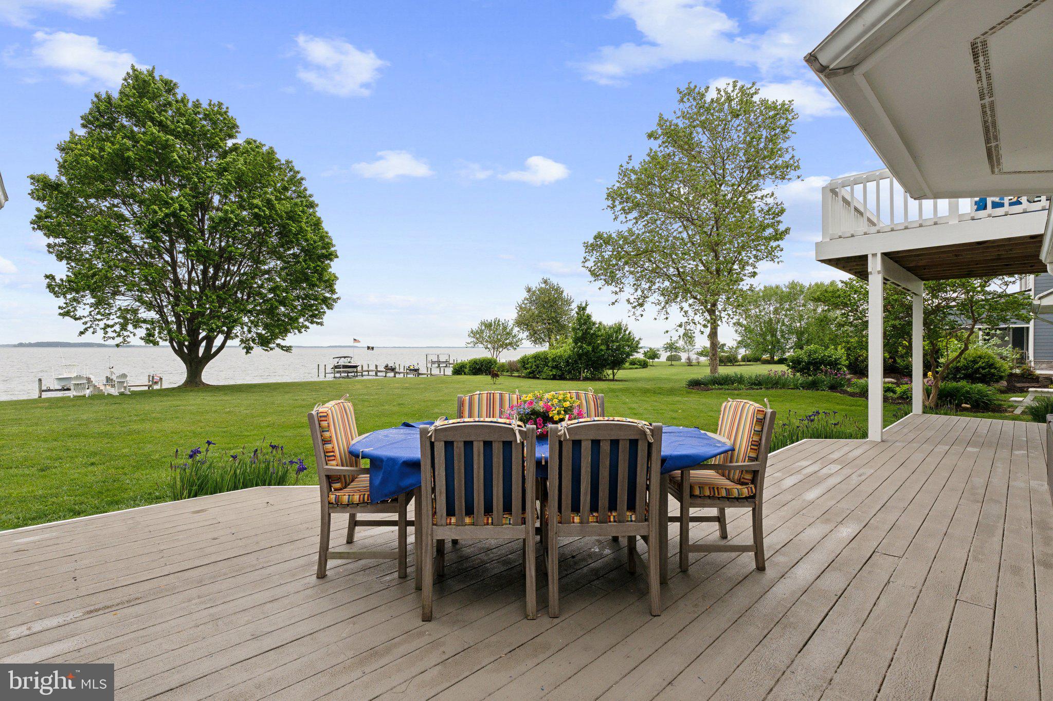 2921 Cox Neck Road East Chester, MD 21619 - Photo 18 of 66 a view of a patio with table and chairs potted plants and a palm tree