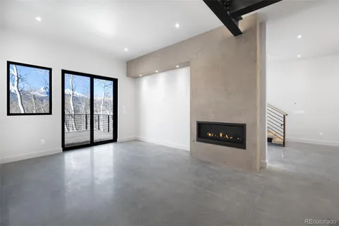 an empty room with windows and fireplace