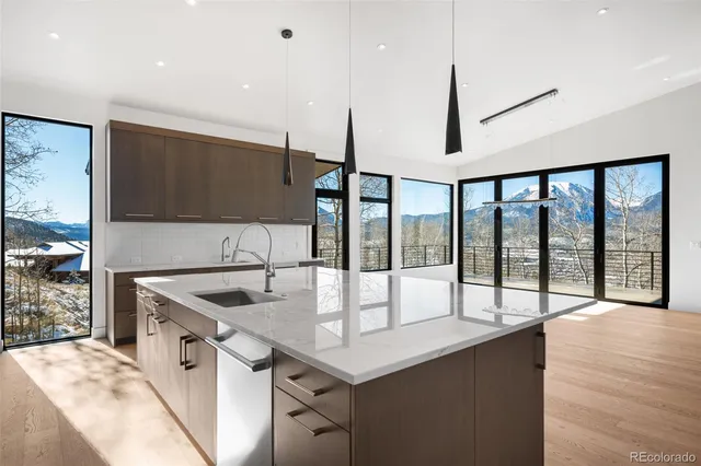 a kitchen with stainless steel appliances granite countertop a sink a stove and a wooden floors