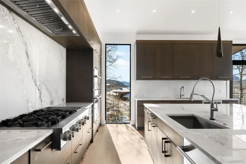 a kitchen with stainless steel appliances granite countertop a sink and a stove