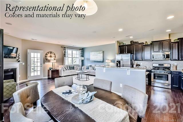 1663 Corwin Bend Road Tega Cay, SC 29708 - Photo 3 of 9 a open kitchen with stainless steel appliances granite countertop a stove a sink a dining table and chairs with wooden floor