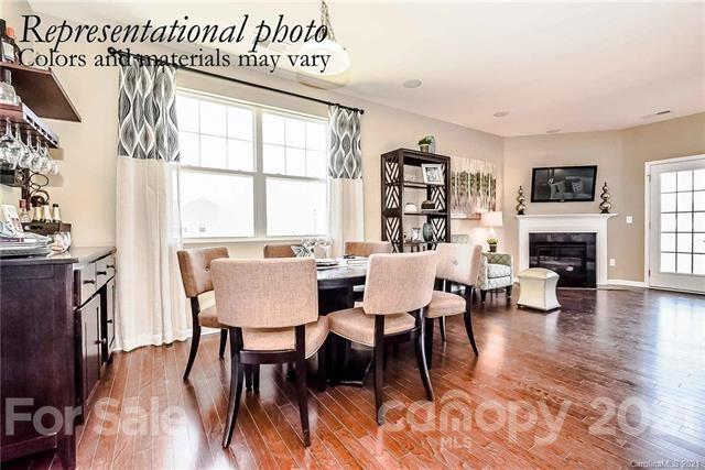 1663 Corwin Bend Road Tega Cay, SC 29708 - Photo 5 of 9 a dining room with furniture a fireplace and wooden floor