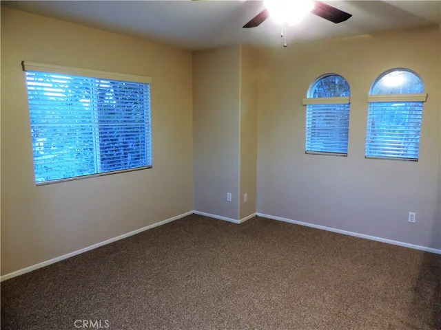 a view of an empty room with a window and cabinet