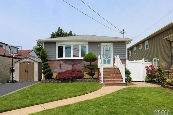 1701 Rugby Road Merrick, NY 11566 - Photo 1 of 1 a front view of a house with a garden
