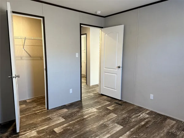 an empty room with closet and windows