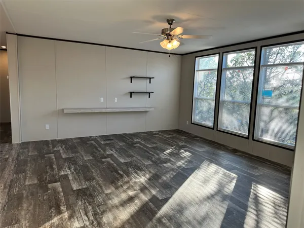 a view of a livingroom with a dishwasher and a large window with wooden floor