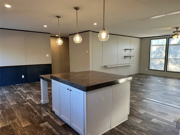 a kitchen with a stove and a wooden floor