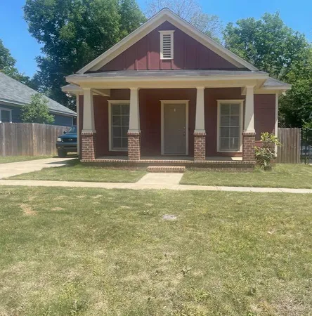 a view of a yard in front of a house with large windows