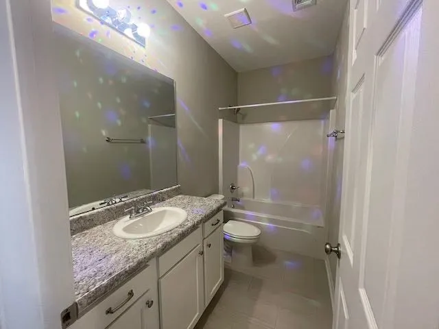 a bathroom with a granite countertop sink toilet mirror and shower