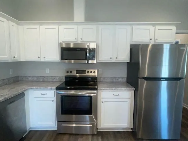 a kitchen with white cabinets and stainless steel appliances