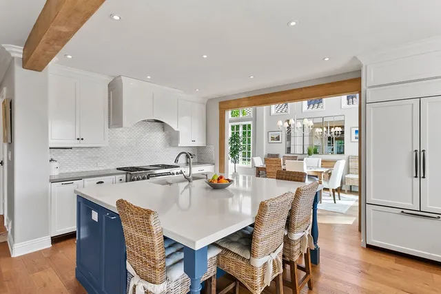 a kitchen with a stove a refrigerator a dining table and chairs with wooden floor