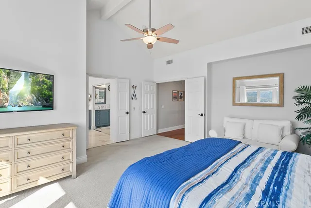 a bedroom with a large bed and a chandelier