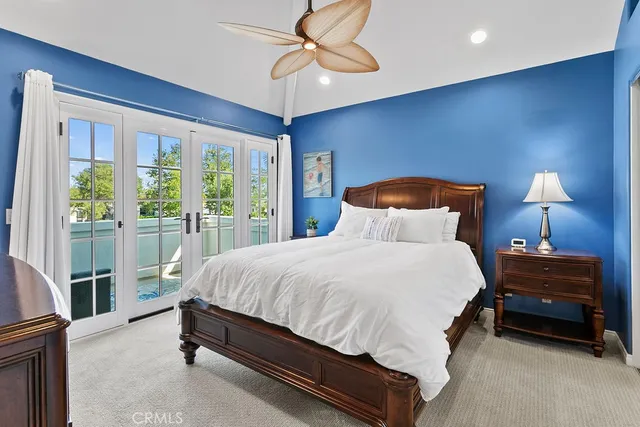 a bedroom with a bed lamp and a large window